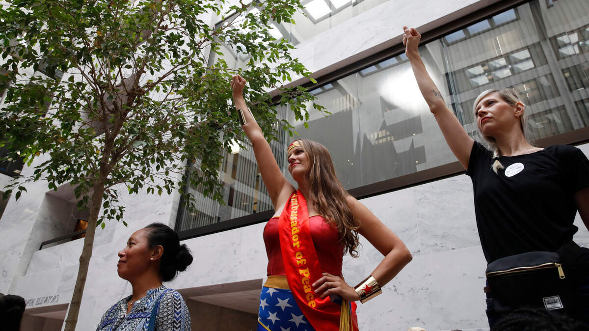 Dos mujeres levantan sus puños en apoyo a la doctora Christine Blasey Ford el 28 de septiembre, durante las protestas en el Capitolio, en Washington D.C., contra la nominación del juez Brett Kavanaugh a la Corte Suprema de Justicia.