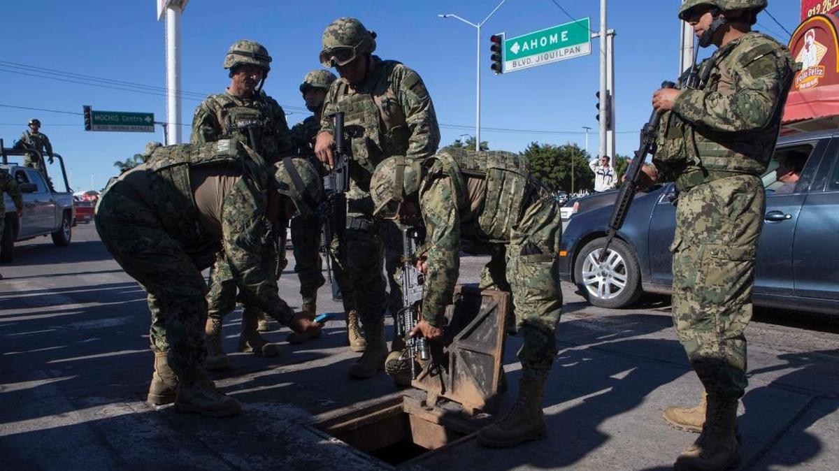 Soldados mexicanos inspeccionan una alcantarilla donde se encontraron armas de alto calibre en el barrio donde las fuerzas especiales capturaron al narcotraficante Joaquín “El Chapo” Guzmán en Los Mochis, el 9 de enero.