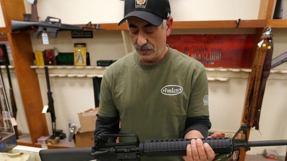 
El gerente de una tienda en New Castle, Pensilvania, muestra un fusil militar a la venta en su establecimiento, en el 2013.
