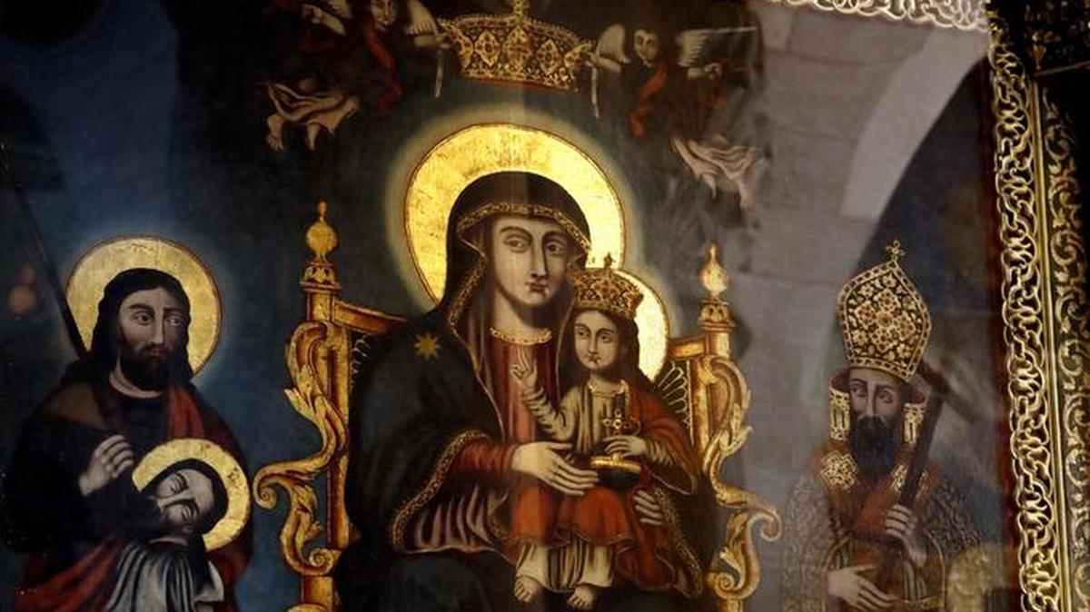 Un empleado limpia el cuadro de la Virgen María y el Niño Jesús en la Iglesia del Santo Sepulcro, en Jerusalén.