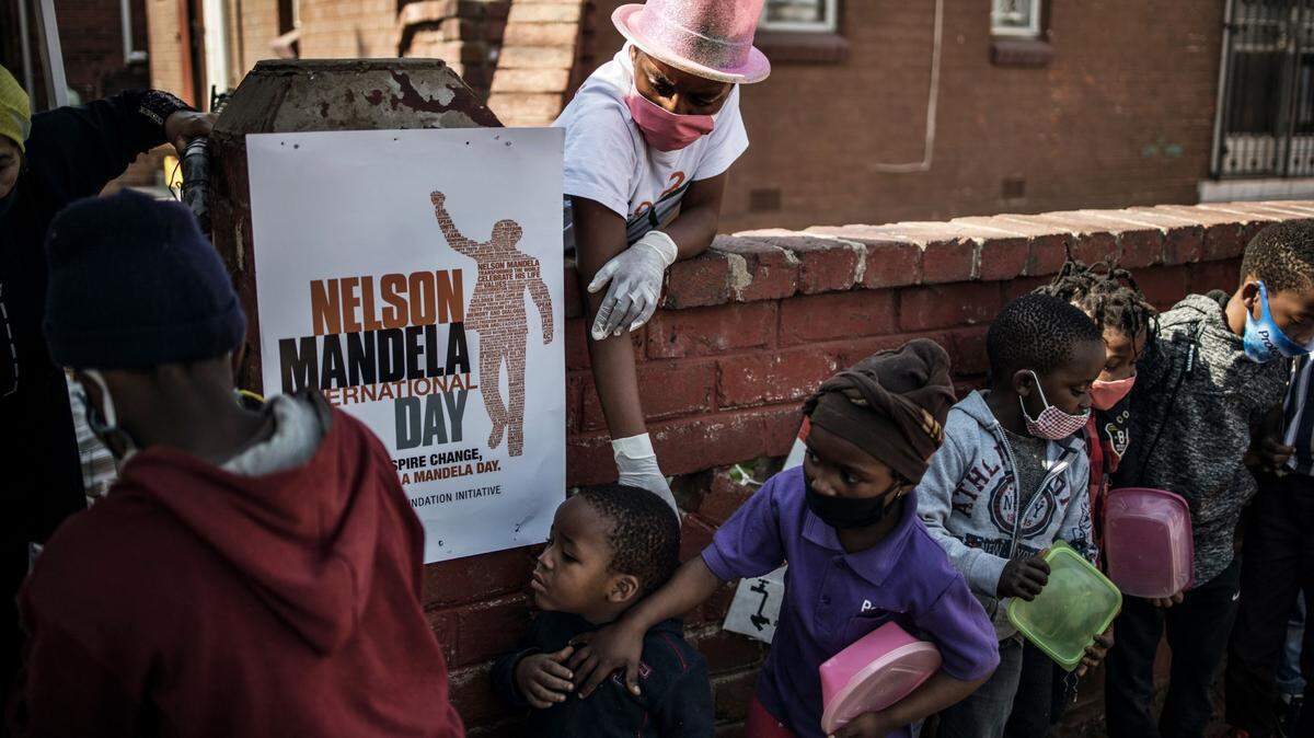 Decenas de niños hacen fila para recibir una comida distribuida por la organización “Hunger has no Religion” (El hambre no tiene religión), el 18 de julio de 2020 en Johannesburg, Sudáfrica.