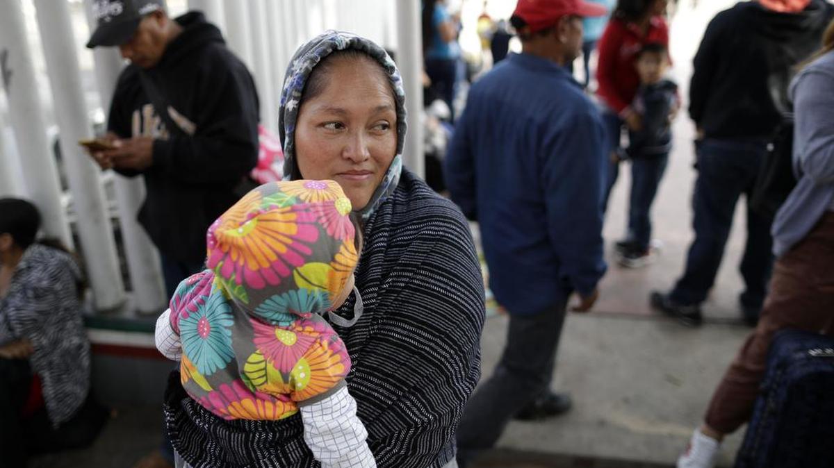 Una inmigrante mexicana carga a su hija en la frontera con Estados Unidos en Tijuana, el 13 de junio, con la esperanza de poder solicitar asilo.