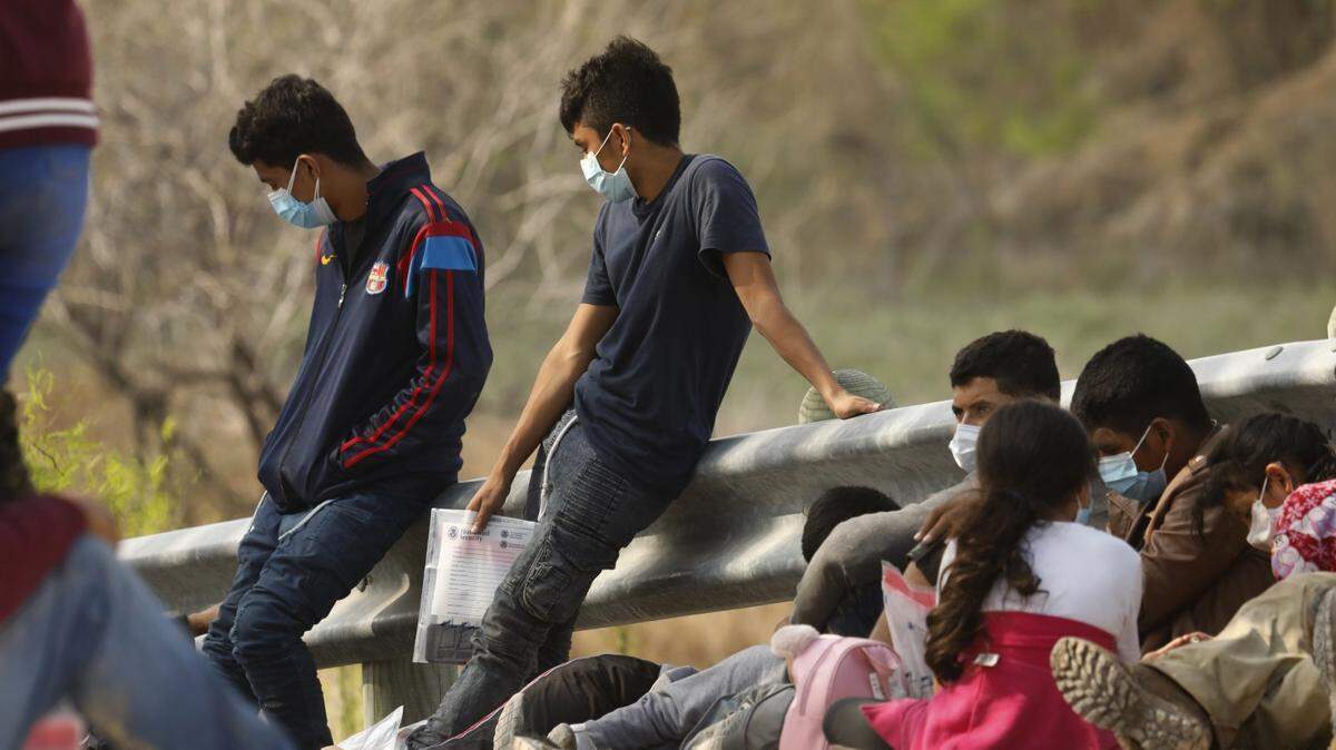 Solicitantes de asilo que cruzaron la frontera entre Estados Unidos y México esperan para ser procesados en Mission, Texas, el 19 de marzo de 2021.