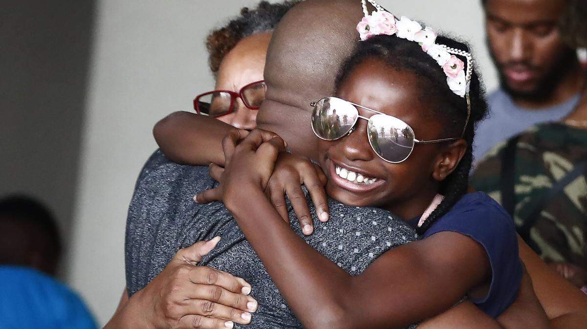 Mark Winder (centro), de Tampa, abraza a su sobrina Gabriella Winder, de 10 años, y a su madre, Marcia Winder, ambas de Freeport, las Bahamas, cuando llegan al puerto de Palm Beach, Florida, el sábado 7 de septiembre de 2019.