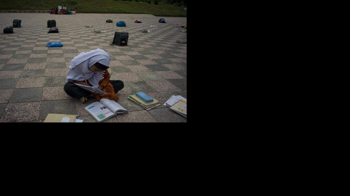 
Una estudiante paquistaní de un arrabal de Islamabad estudia en una escuela improvisada en un parque. La ley islámica les niega la educación a las mujeres.

