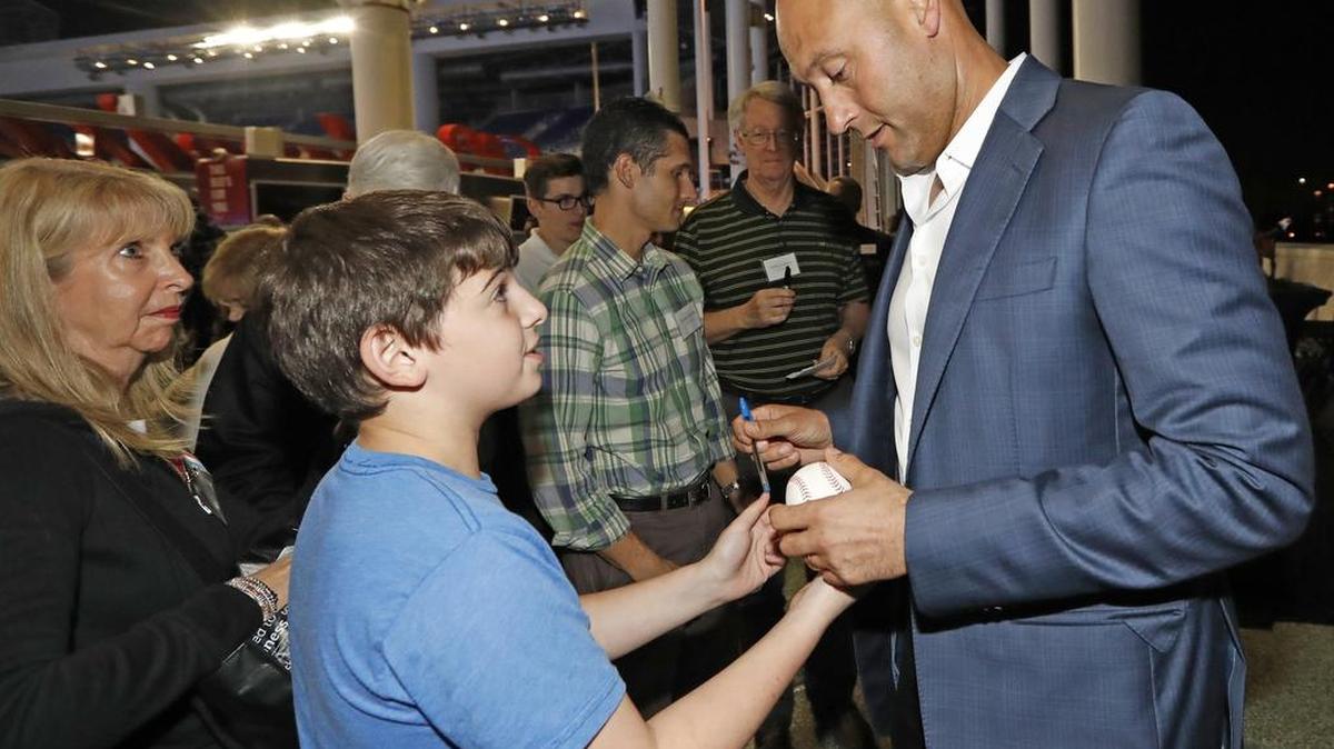 Derek Jeter, copropietario de los Miami Marlins, se reúne con fans del equipo y firma una pelota en el estadio de los Marlins, el 19 de diciembre.