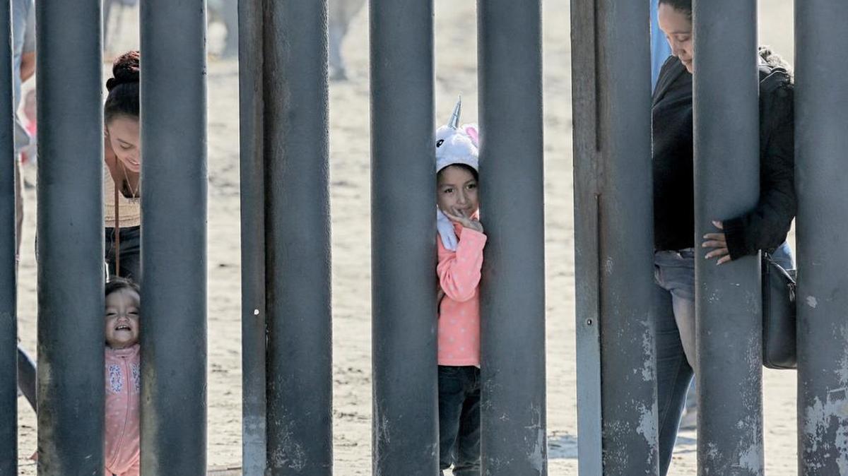 Una niña saluda a través del muro fronterizo entre Estados Unidos y México, en Friendship Park en San Ysidro, California.