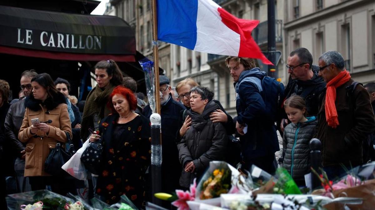 Un grupo de personas se reúne frente al café Le Carillon, uno de los sitios de París atacados por los terroristas. El presidente François Hollande dijo que las víctimas eran de 19 nacionalidades.