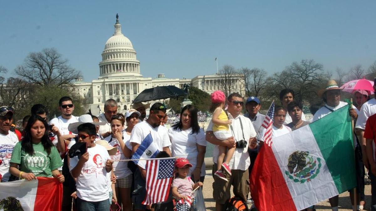 Inmigrantes mexicanos sostienen banderas en una manifestación en Washington, DC.