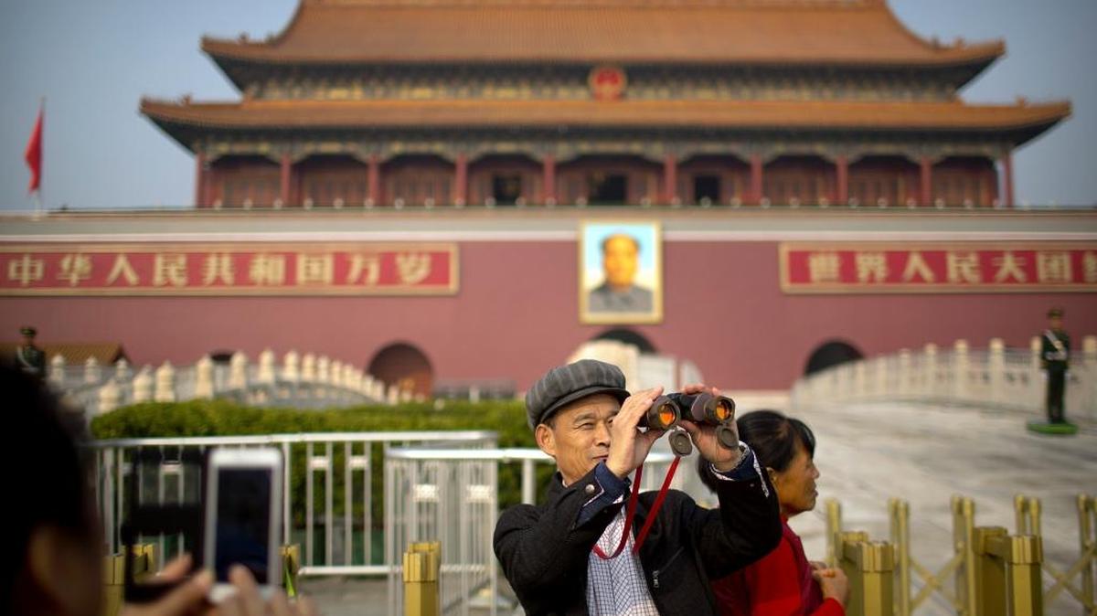 Un hombre usa sus binoculares frente a la puerta de Tiananmen, en Pekín. El presidente Donald Trump visitará China este miércoles.