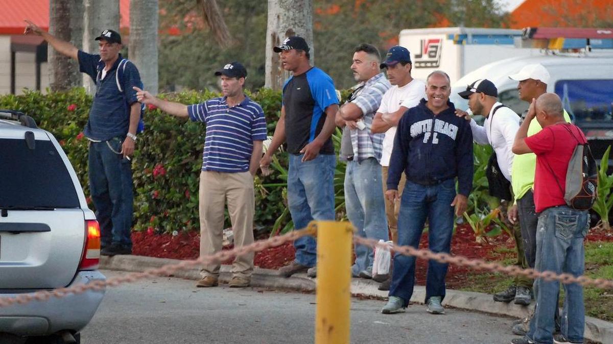 Jornaleros, entre ellos algunos inmigrantes indocumentados, esperan cerca de un Home Depot en Miami que contratistas les ofrezcan trabajo, el pasado febrero.