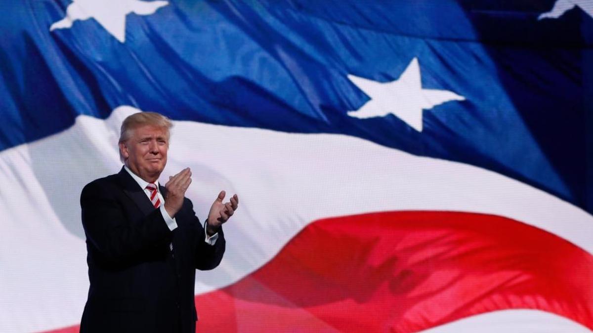 El candidato presidencial republicano Donald Trump se acerca a felicitar a su compañero de boleta, el vicepresidente nominado Mike Pence, gobernador de Indiana, en la tercera jornada de la Convención Nacional Republicana en Cleveland, el 10 de julio.