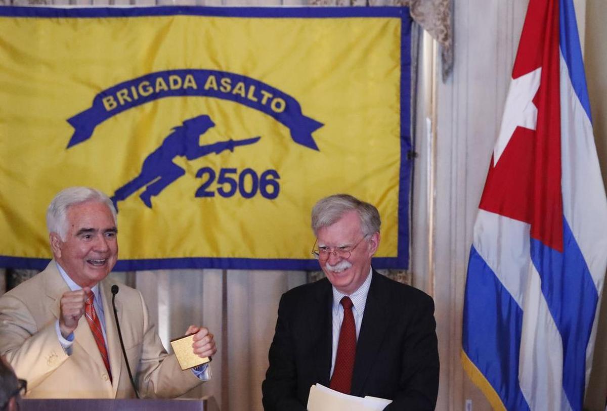 J.R. “Johnny” Lopez de la Cruz, left, president of the Bay of Pigs Veterans Association Brigade 2506, presents a medallion to National Security Advisor John Bolton Wednesday, April 17, 2019, in Coral Gables, Fla., at the Bay of Pigs Veterans Association on the 58th anniversary of the United States’ failed 1961 invasion of the island. The Trump administration on Wednesday intensified its crackdown on Cuba, Nicaragua and Venezuela, the three countries whose leaders Bolton dubbed the “three stooges of socialism.”