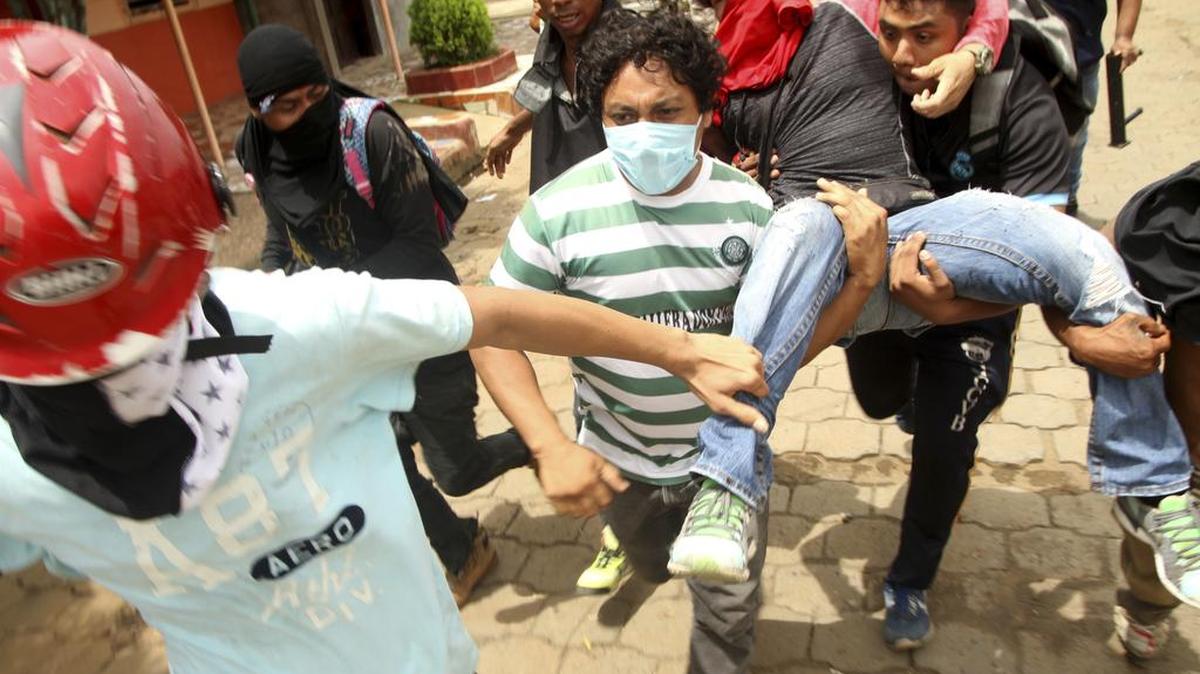 Opositores al gobierno de Daniel Ortega llevan a un compañero herido mientras las fuerzas estatales entran en la ciudad de Masaya, el 19 de junio.