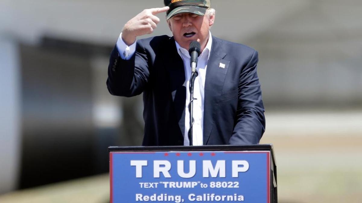 El candidato republicano Donald Trump señala su gorra, con un letrero que reza: ‘Make America Great’, en el Redding Municipal Airport en Redding, California.