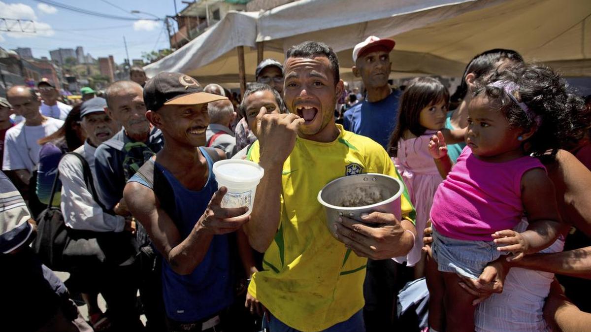 Un hombre con una olla vacía exclama: “Tengo hambre” en un acto de campaña electoral de candidato presidencial Javier Bertucci en Caracas, el 12 de mayo.