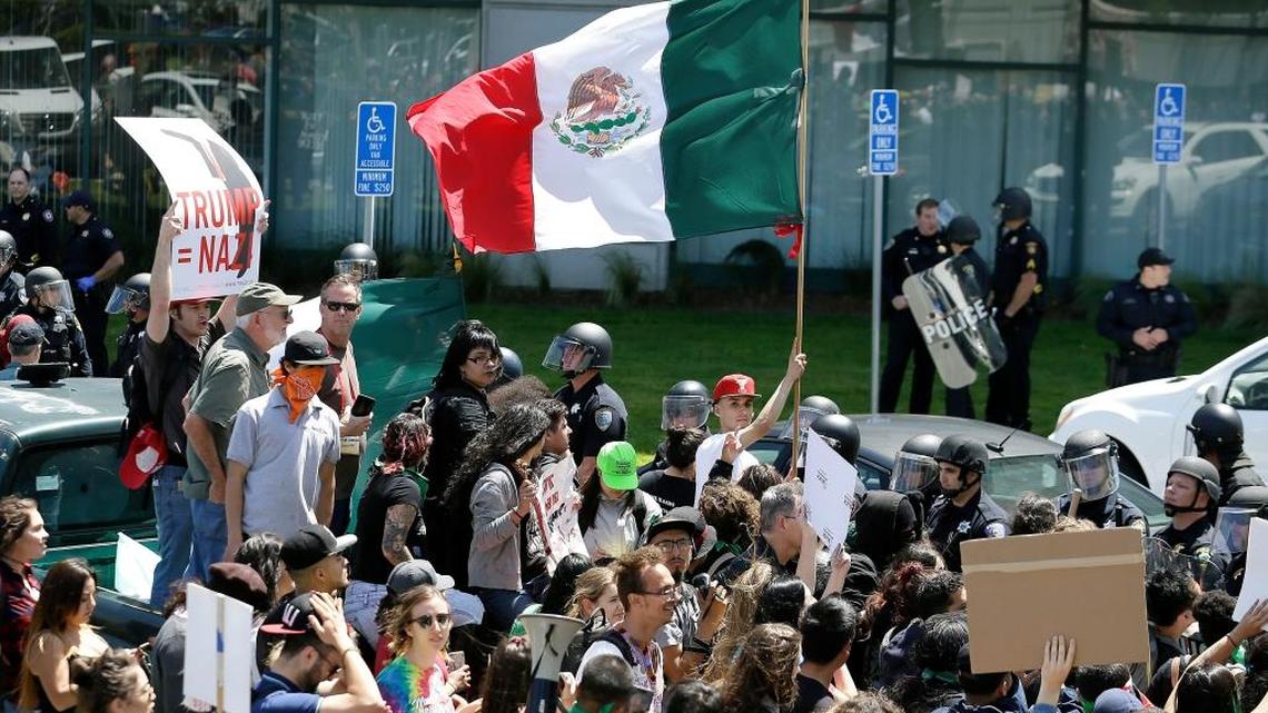Manifestantes contra el candidato presidencial republicano Donald Trump portan banderas mexicanas frente al hotel Hyatt Regency, en Burlingame, California, donde se celebró la Convención del Partido Republicano de California, el 29 de abril.