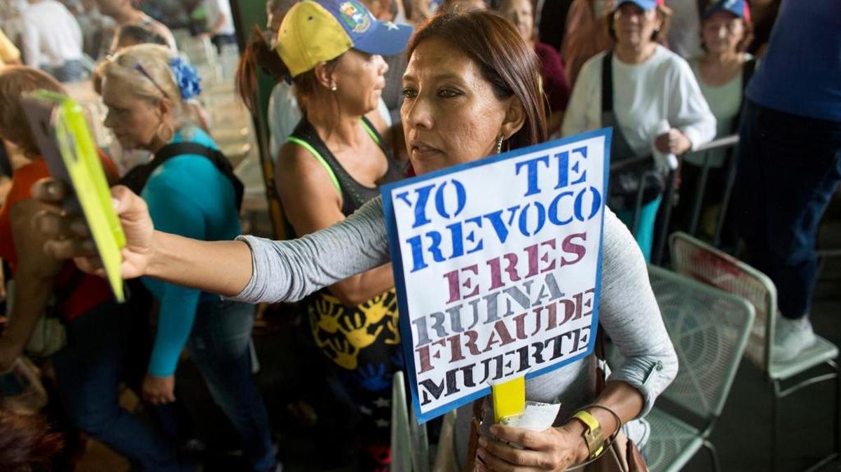 Una mujer participa en una manifestación en Caracas, el 19 de abril, con un cartel que lleva un mensaje para el gobernante Nicolás Maduro.