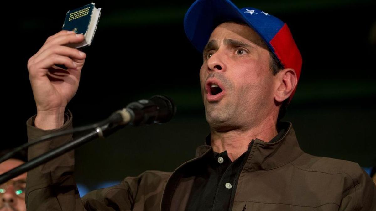 El líder opositor Henrique Capriles sostiene una copia de la Constitución al hablar a partidarios y prensa en un mitin en Caracas, el 7 de abril.