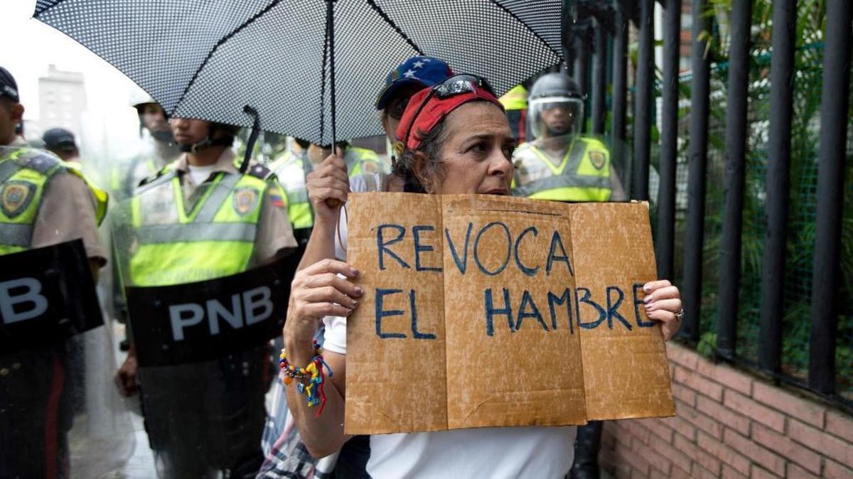 Una mujer sostiene un letrero que dice: ‘Revoca el hambre’ en una marcha de protesta en Caracas, el 27 de julio.