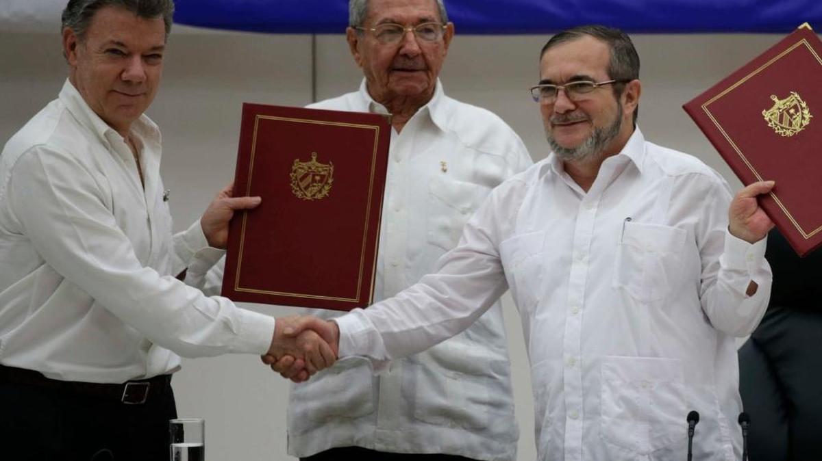 El presidente colombiano Juan Manuel Santos (izq) con el comandante Timoleón Jiménez de las FARC (der), acompañados por el gobernante cubano Raúl Castro en La Habana el 23 de junio del 2016.