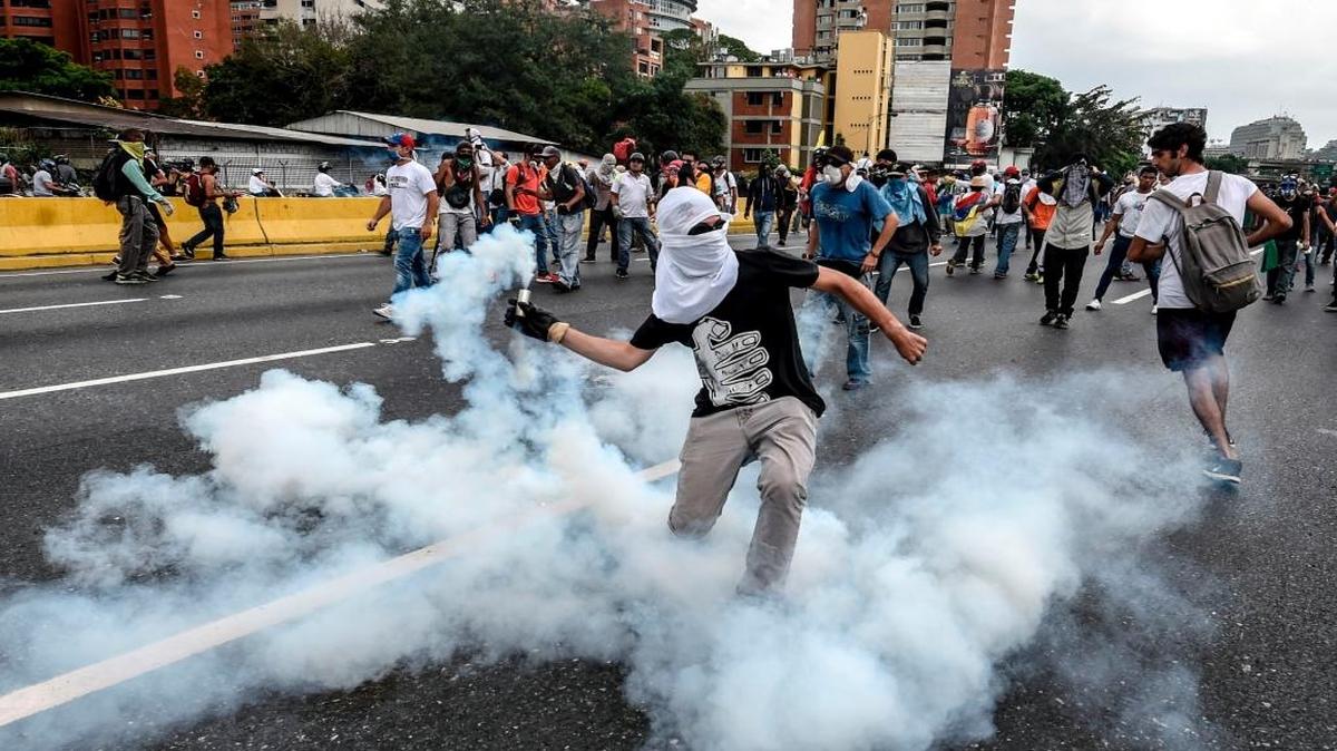Manifestantes se enfrentan a la policía en medio de gases lacrimógenos en una protesta contra el gobierno de Nicolás Maduro, el 20 de abril, en Caracas.