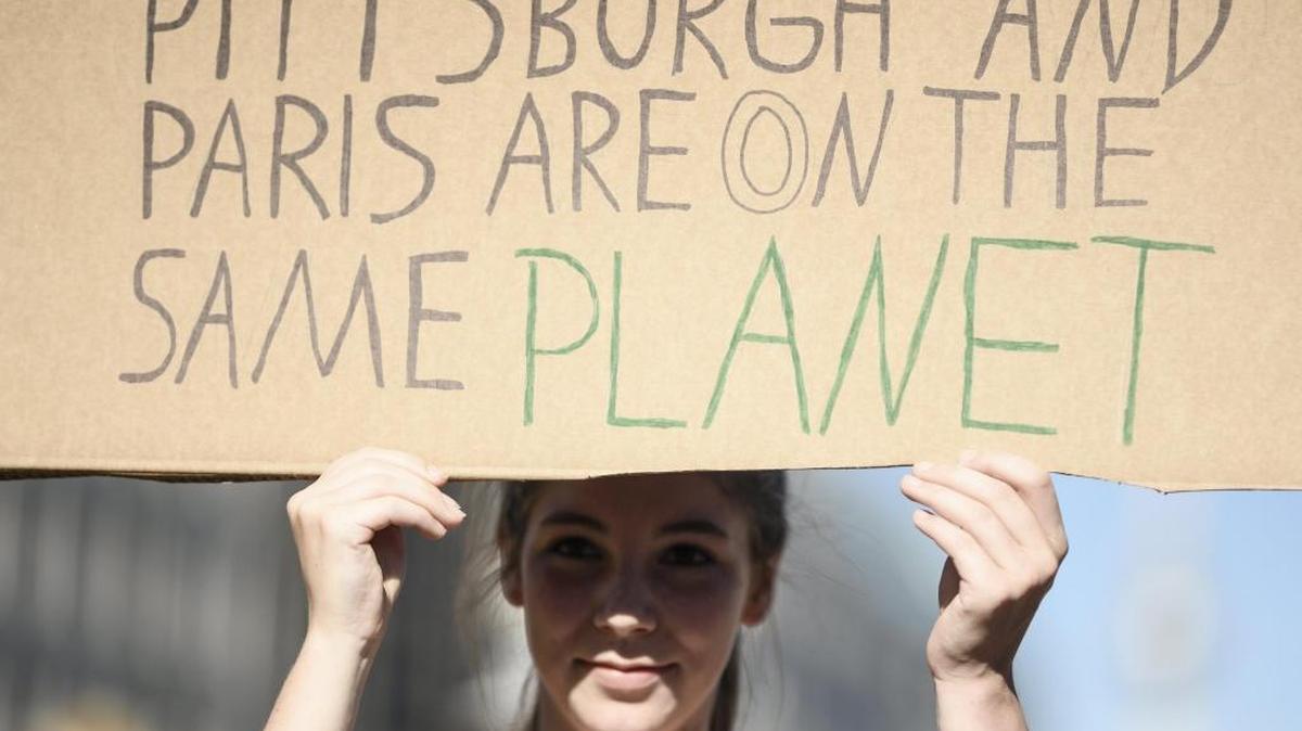 Una manifestante sostiene una pancarta en la que se lee 'Pittburgh y París están en el mismo planeta', durante las protestas contra la salida de Estados Unidos del Acuerdo de París, en Berlín el 2 de junio.