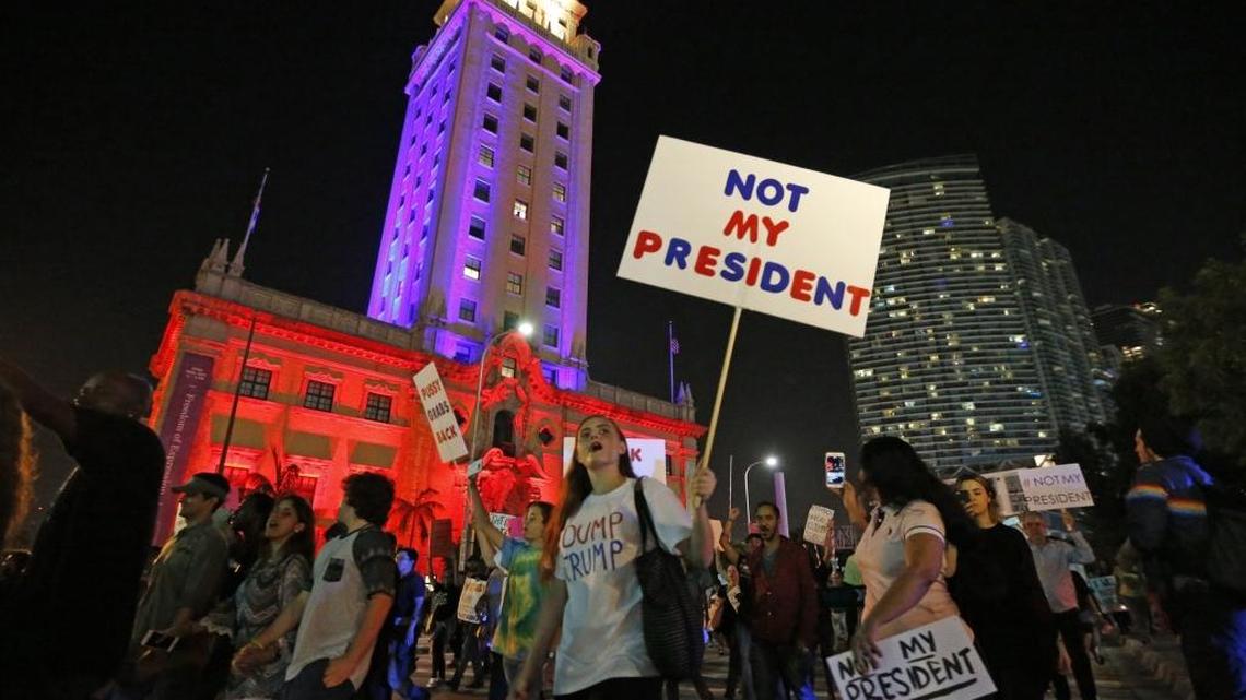 Manifestantes marchan en Biscayne Boulevard frente a la Torre de la Libertad, en Miami, en protesta por la elección de Trump.