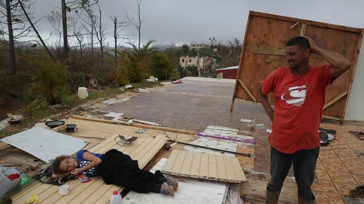 Una niña y su padre observan los restos de su casa en la localidad puertorriqueña de Hayales de Coamo, el domingo pasado. El huracán María causó daños devastadores en la isla caribeña.