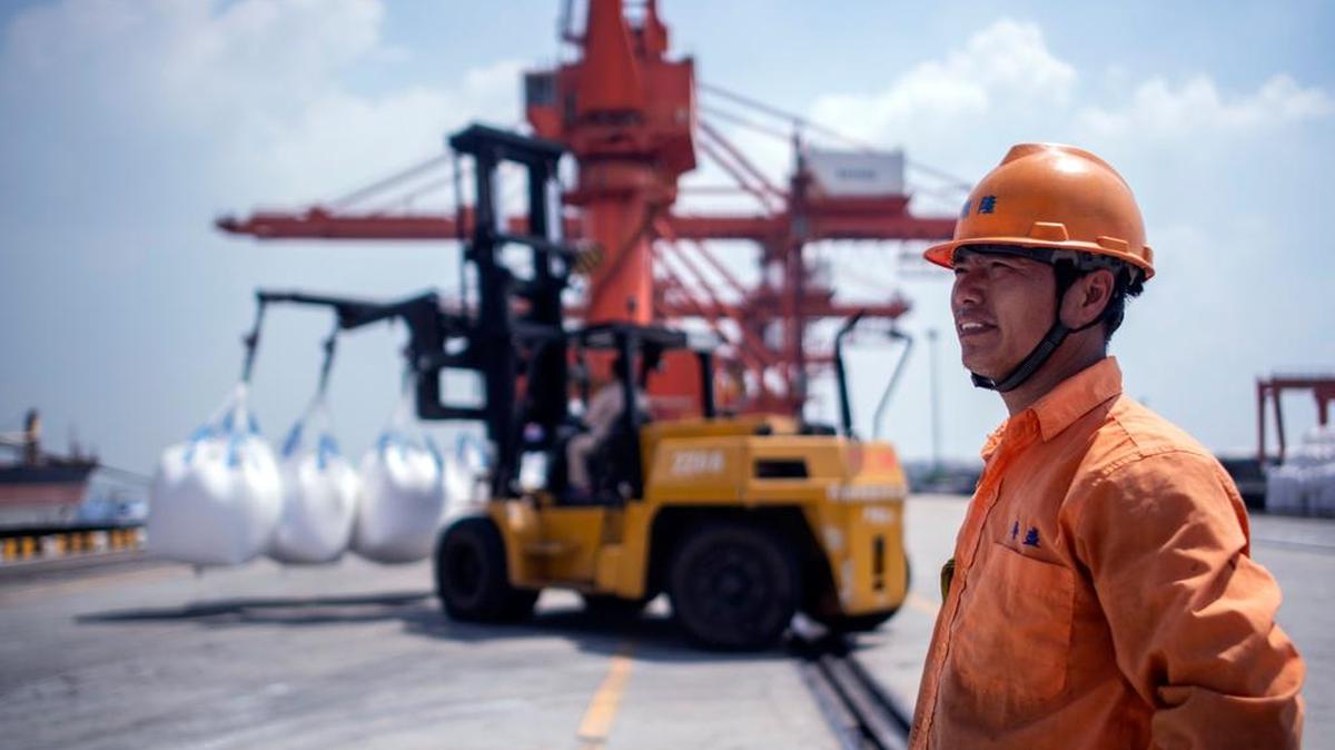 Un empleado observa la descarga de un buque en el puerto chino de Zhangjiagang. El superávit comercial de China frente a Estados Unidos se redujo en julio.