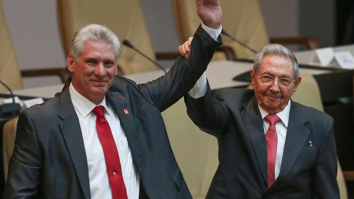 El nuevo presidente del Consejo de Estado y de Ministros de Cuba, Miguel Díaz-Canel (izq.), y el mandatario saliente Raúl Castro alzan el brazo en señal de triunfo en la Asamblea Nacional, en La Habana, el 19 de abril.