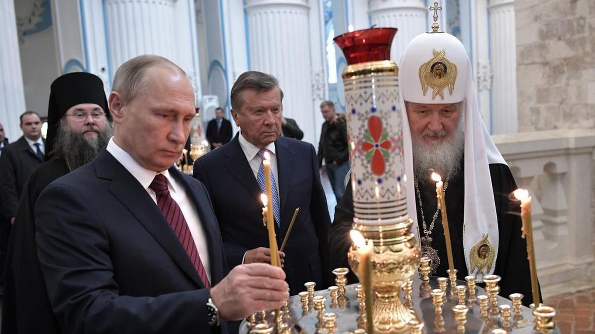 El patriarca de la iglesia ortodoxa de Rusia, Kirill (der.) y el presidente de esa nación, Vladimir Putin, encienden velas mientras visitan el Monasterio de la Resurrección de Nueva Jerusalén, en Moscú, Rusia.