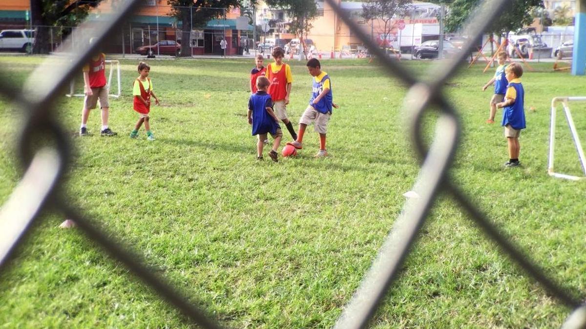 Un grupo de niños juega fútbol en el Riverside Park en la avenida 7 entre la calle 3 y la 4 en la Pequeña Habana, donde ocurrió un tiroteo el lunes 26 octubre.