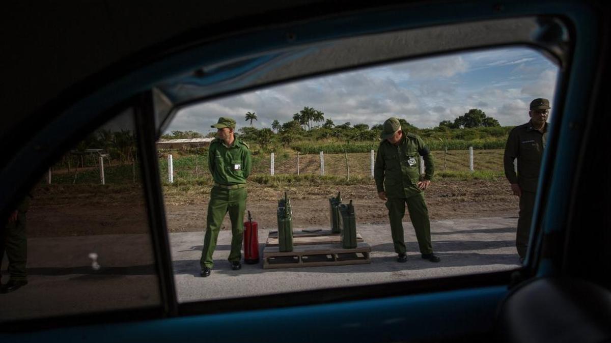Soldados custodian recipientes de gasolina para rellenar el tanque de los vehículos de la caravana que transporta las cenizas de Castro.