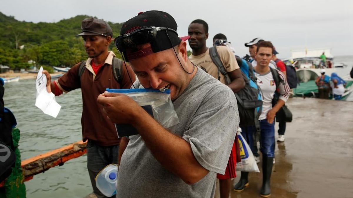 Marcelino Quintana (izq.) y Alexander Gutiérrez García, cubanos, se bajan de un ferry en Capurgana, Colombia, en camino hacia Panamá, para llegar a EEUU.