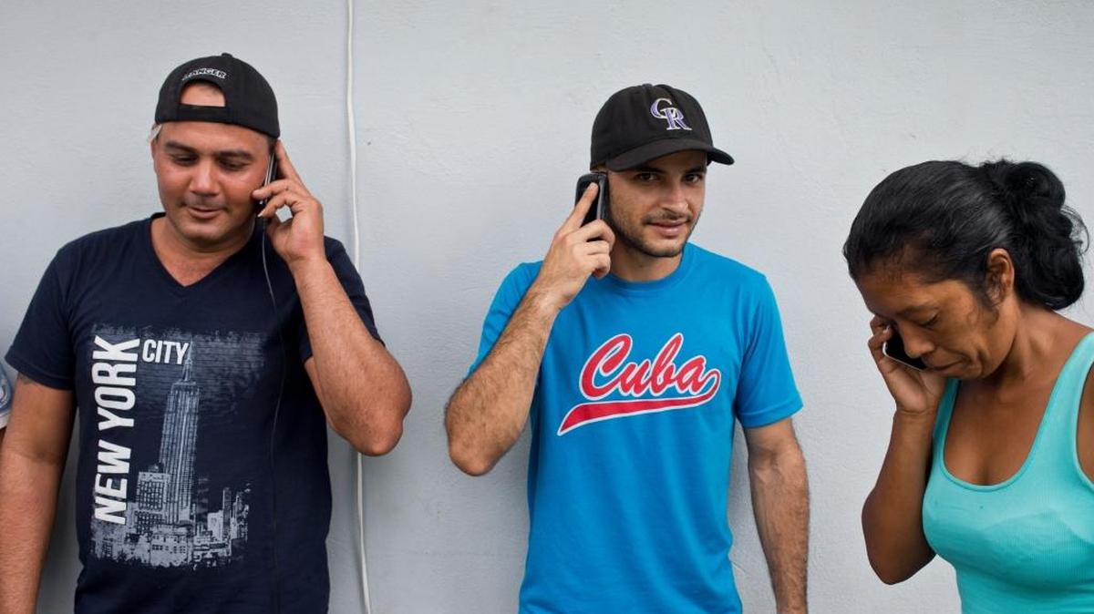 Inmigrantes cubanos hablan por celulares en Peñas Blancas, Costa Rica, en la frontera con Nicaragua, el 21 de noviembre.