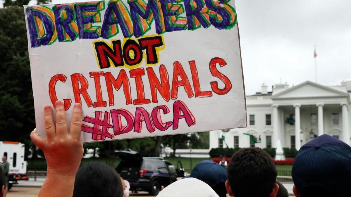 Una manifestantes sostiene un cartel a favor de los Dreamers en una protesta para que se mantenga el programa de DACA, el 15 de agosto, frenta a la Casa Blanca, en Washington, D.C.