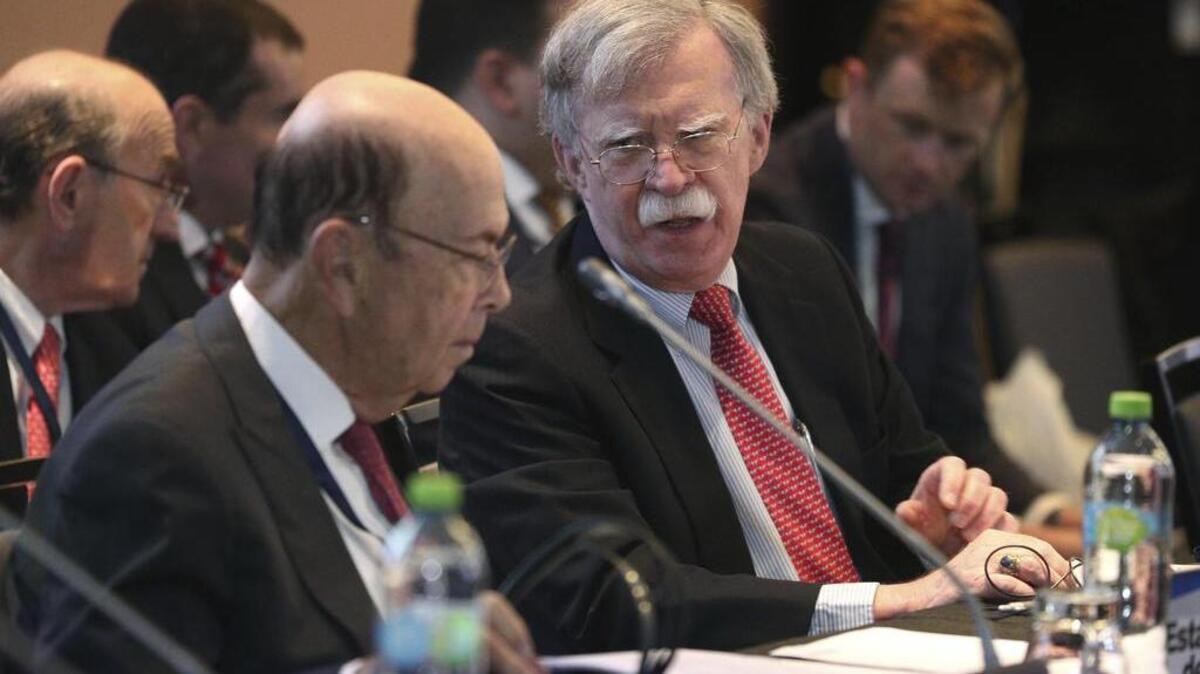 John Bolton, asesor de seguridad nacional de Estados Unidos (der.), conversa con Wilbur Ross, secretario del Comercio de EEUU, durante una conferencia de naciones que apoyan al presidente interino de Venezuela, Juan Guaidó, el martes 6 de agosto de 2019, en Lima, Perú.