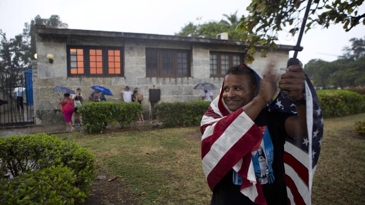 Un hombre envuelto en la bandera de Estados Unidos aplaude al paso del convoy del presidente Barack Obama por La Habana el 20 de marzo.