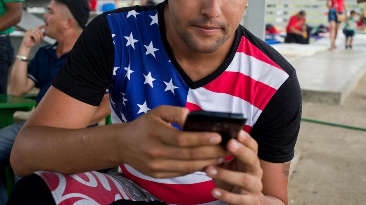 Un migrante cubano en un refugio en La Cruz, Costa Rica, en noviembre. Muchos de los cubanos llevan ropas con banderas norteamericanas y se valen del telefono para seguir el viaje.