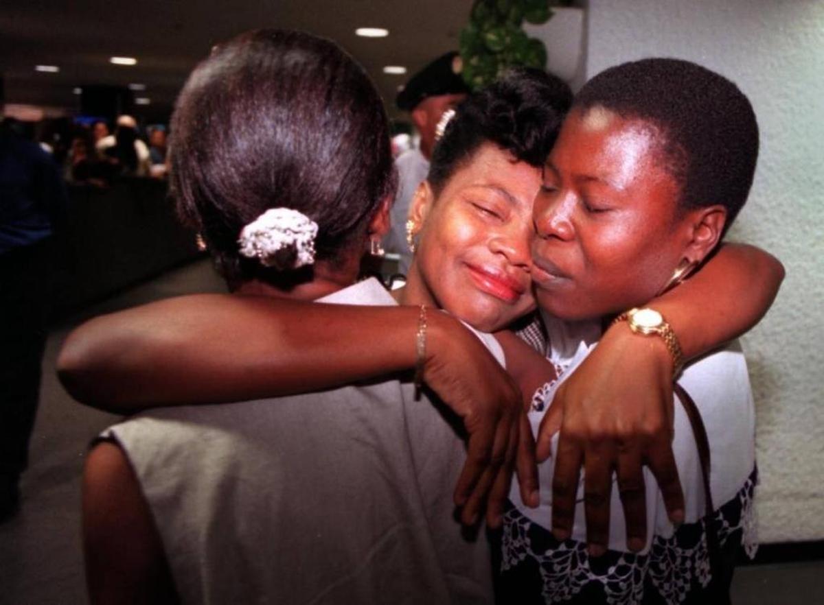 Marie-Esperancia Fortin, de Naples, Florida, abraza a sus dos hermanas al llegar al Aeropuerto Internacional de Miami, desde Haití, en 1996.