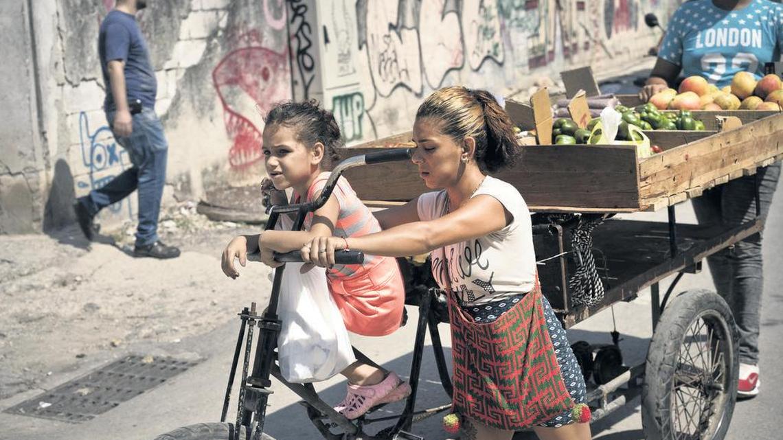 Una niña y su madre se desplazan en una bicicleta con una carreta de vegetales por una calle de La Habana Vieja, el sábado. El gobierno cubano anunció que comenzará a racionar el pollo, huevos, arroz, y otros productos básicos.