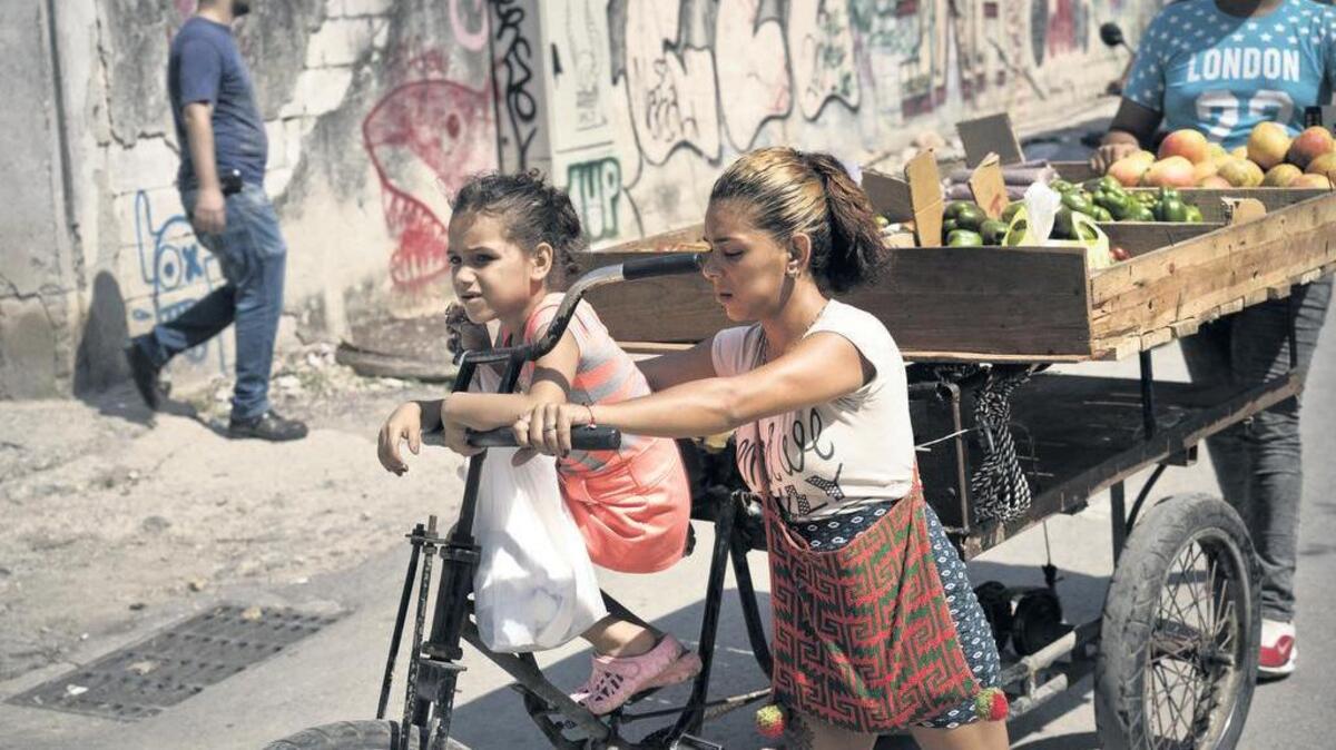Una niña y su madre se desplazan en una bicicleta con una carreta de vegetales por una calle de La Habana Vieja, el sábado. El gobierno cubano anunció que comenzará a racionar el pollo, huevos, arroz, y otros productos básicos.