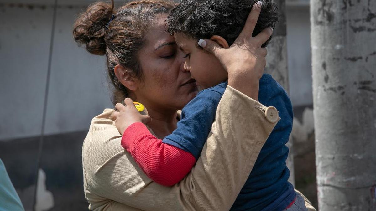 Una madre abrazo a su hijo después que él y su padre llegaron en un vuelo de ICE tras ser deportados de Estados Unidos, el jueves 22 de agosto de 2019, en Ciudad de Guatemala.