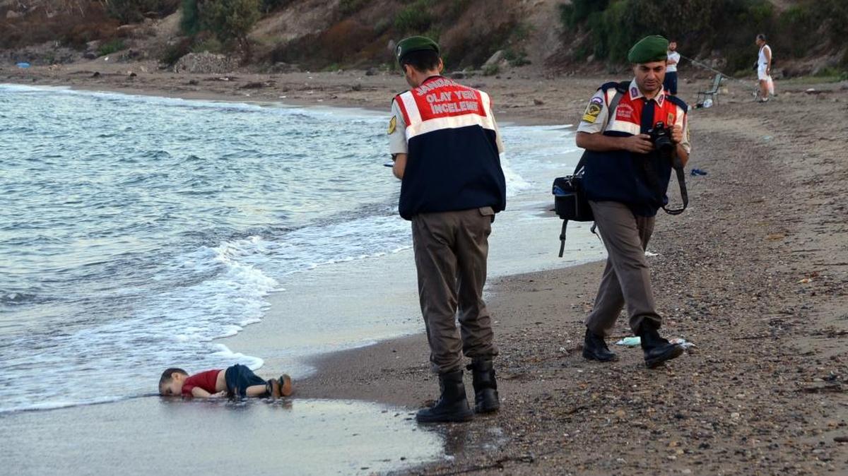 
Agentes de policía se disponen a recoger el cadáver de Aylan Kurdi, un niño sirio, en una playa de Turquía.
