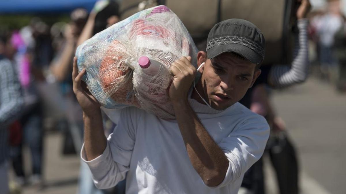 Un venezolano cruza el puente Simón Bolívar cargando provisiones desde Colombia en dirección a San Antonio del Táchira, Venezuela, el 20 de diciembre.