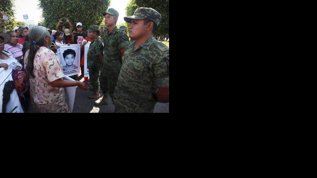 
Familiares de estudiantes desaparecidos protestan frente a una base militar en la localidad mexicana de Iguala, el jueves pasado.
