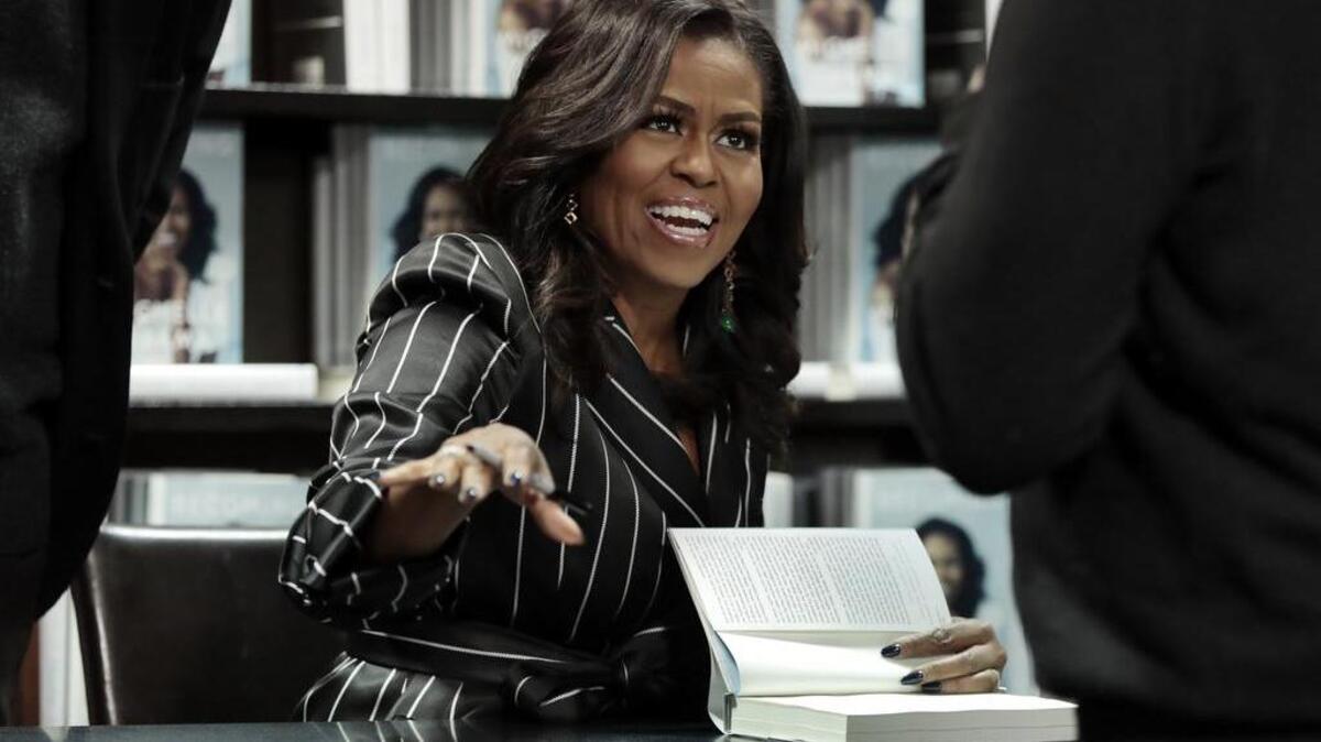 La ex primera dama Michelle Obama firma copias de su autobiografía “Becoming”, el 30 de noviembre en Nueva York.