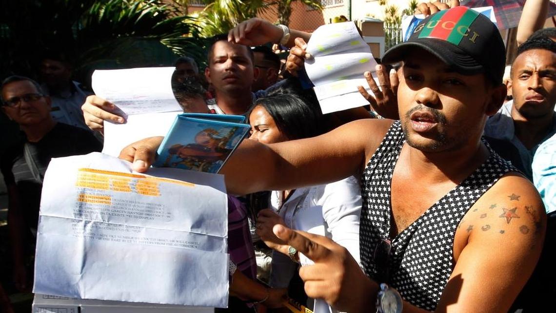 Un hombre, con un pasaporte en mano y algunos documentos que confirman sus planes de viaje, protesta con un grupo de cubanos el 27 de noviembre del 2015, cerca de la embajada de Ecuador en Cuba tras el anuncio de que ese país exigirá visa a todo cubano que ingrese como turista a partir del 1 de diciembre.