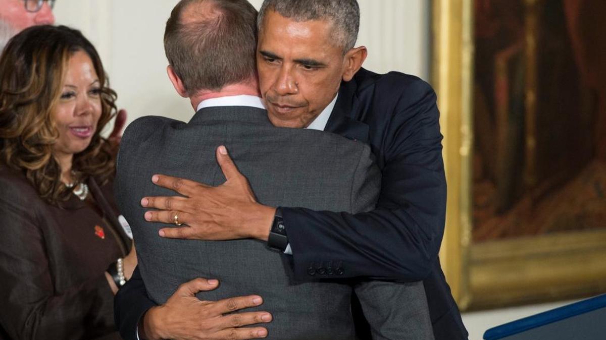 El presidente de EE.UU., Barack Obama (der.) abraza a un padre cuyo hijo fue asesinado en la masacre de la escuela Sandy Hook, tras su dircurso para mejorar el control de la venta de armas en el país.